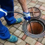 sewer cleaning service - worker clean a clogged drainage with hydro jetting